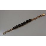 A 14ct gold articulated bracelet mounted seven graduated star sapphires (l.19cm. 29g)