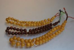 A large string of amber beads, each bead approximately d. 2cm and another yolk coloured string, 1.