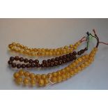 A large string of amber beads, each bead approximately d. 2cm and another yolk coloured string, 1.