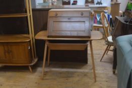 An Ercol light elm bureau desk, the freestanding secretaire top with single frieze drawer above a