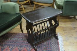 An Ercol dark elm occasional table/magazine rack, raised on shaped pierced side supports (h. 49cm)