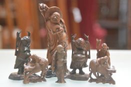 A collection of five various carved wood figures of Buddha and Hoti and a pair of carved treen water