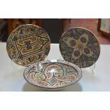 Two Moroccan style plates decorated with traditional scrolls, flowers, symbols etc., (d.29cm) and