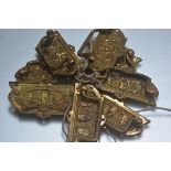 A set of eight 19th century embossed brass bale handles with mask panels. Each 4.5cm by 9cm
