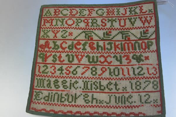 A Victorian sewn work sampler by Maggie Nisbet, 1878, Edinburgh, June 12th, on cotton backing with