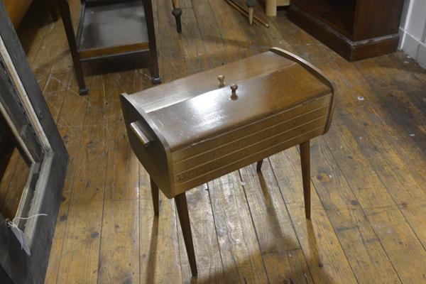 A 1950's oak sewing box with twin folding open panel doors enclosing a fitted interior. 45cm by 46cm