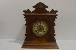 An Edwardian oak mantel clock with enamel dial, pedimented top. 41cm by 35cm by 14cm