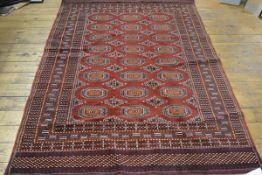 A Bokhara rug, the centre panel with three rows of octagons enclosed within a triple stylised