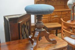 A Victorian walnut circular seat adjustable piano stool, on tripod base.