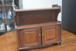 An Edwardian stained walnut wall cabinet with open shelf to top and two panelled doors. 54cm by 57cm