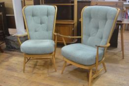 A pair of light elm Ercol high back open arm easychairs with green button back and seat squab