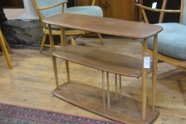 An Ercol light elm three tier stand with turned twin column supports (missing ball castors, top a/