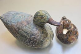 A carved pine duck and a ceramic paisley patterned duck (larger: h.18cm)