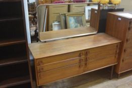 A Meredew teak dressing chest, the rectangular mirror with curved corners above an arrangement of