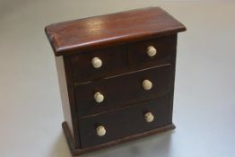 A Victorian stained pine miniature chest fitted two short and two long drawers, on plinth base (h.