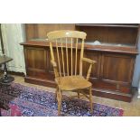 A late 19thc elm spindle back open arm kitchen chair with shaped wood seat, on ring turned splay