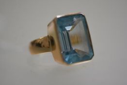 A yellow metal dress ring mounted cushion cut treated aquamarine (size N) (12.16g)