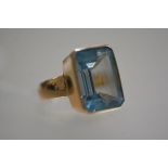 A yellow metal dress ring mounted cushion cut treated aquamarine (size N) (12.16g)