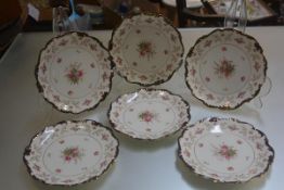 A set of six Edwardian Coalport handpainted scalloped dessert plates with rose and fern