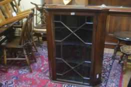 A 19thc mahogany wall corner cabinet with glazed astragal panel door enclosing a shelved interior (