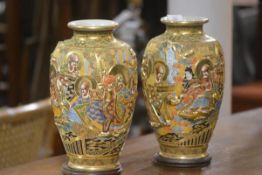 A pair of Japanese Kaga baluster vases with moulded lohan and holyman figures in landscapes,