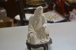 A Japanese blanc de chine figure of Monk holding beads and Fan (losses and firing crack to base),