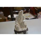 A Japanese blanc de chine figure of Monk holding beads and Fan (losses and firing crack to base),