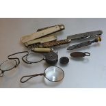 A collection of five various pocket knives, a pair of metal pince nez, a monacle, a folding tape