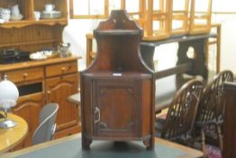 An Edwardian walnut corner two tier cabinet fitted single panel door and shaped sides (h.66cm x