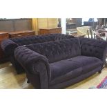 A pair of modern two seater Chesterfield button back sofas upholstered in plum plush fabric,