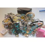 A bag containing a large collection of costume jewellery including pendants, earrings, brooches etc.