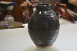 A pottery baluster vase with brown glaze, impressed mark verso M.R. (h.30cm)