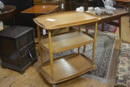 An Ercol light elm three tier trolley the top with moulded rounded angles and open border raised