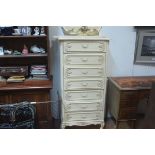 An American cream and gilt painted tallboy chest, the scalloped top with ledge back above seven long