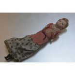 A late 19thc treen wax coated headed doll with flapper style hair in long dress, with treen