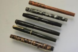 A collection of fountain pens including a Wyvern 404 fountain pen, a Unique Junior fountain pen, a
