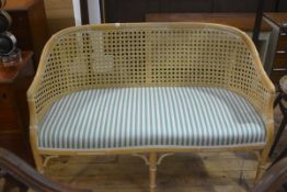 A faux bamboo two seater Regency style cane panel back and stuffover seat sofa, on fluted tapered