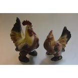 A pair of Continental china cockeral and hen figures with polychrome decoration (restorations to