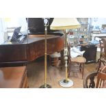 A brass circular column floor lamp raised on circular weighted base and a 1970s onyx and brass