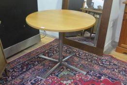 A modern oak circular top pedestal kitchen dining table, on anodised metal tubular support and