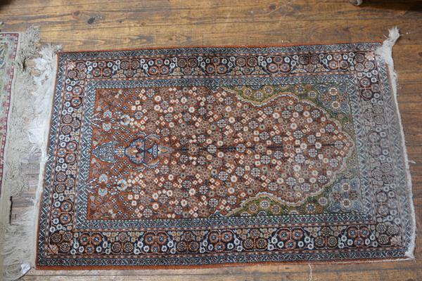 A Nepalese silk prayer rug, the centre rectangle with arched panel and hanging lantern, enclosed