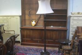 A stained mahogany turned wood and fluted floor lamp raised on circular moulded base, complete