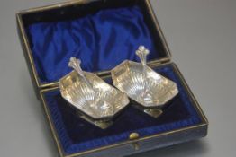 A pair of Epns octagonal fluted salt cellars and a pair of shell bowl fleur de lys handled spoons,