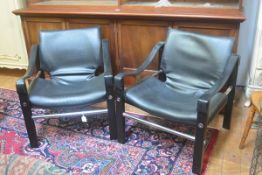 A pair of Arkana English ebonised and black vinyl upholstered back and arm chrome support easy