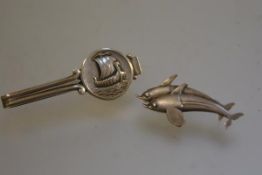 A Georg Jensen viking ship tie clip and a sterling silver double dolphin brooch (l. 5.5cm and 4.