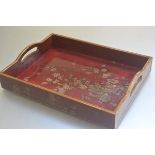 A modern red lacquered two handled rectangular tea tray with prunus and crysanthemum decoration (h.