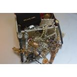 A jewellery box containing a large collection of paste jewellery including pendants, chains,