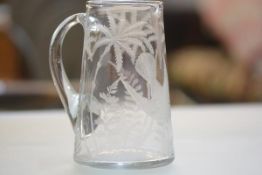 An Edwardian glass water jug with engraved fern, palm trees and flying bird (h.18cm)