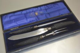 An Edwardian three piece horn handled carving set complete with steel, knife and fork, in original