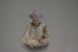 A 19thc Continental porcelain seated figure of a Turk with nodding head, decorated with polychrome